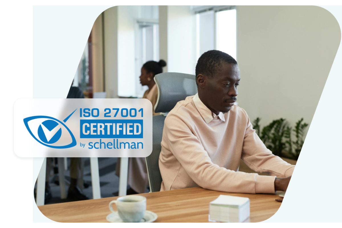 Image showing a man working at his desk overlaid with a badge representing Dashlane’s ISO-27001 certification.