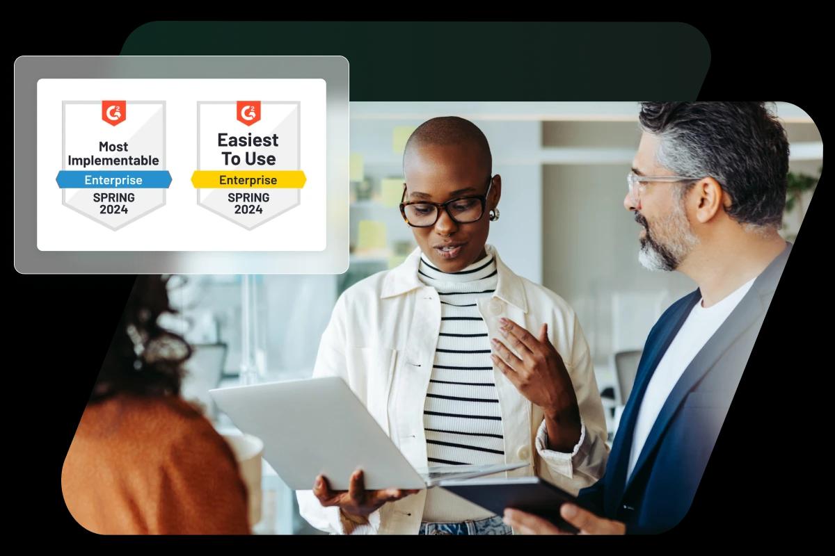 This image shows two employees collaborating overlaid with two G2 badges awarded to Dashlane: “Most Implementable-Enterprise” Spring 2024 and “Easiest To Use - Enterprise” Spring 2024.
