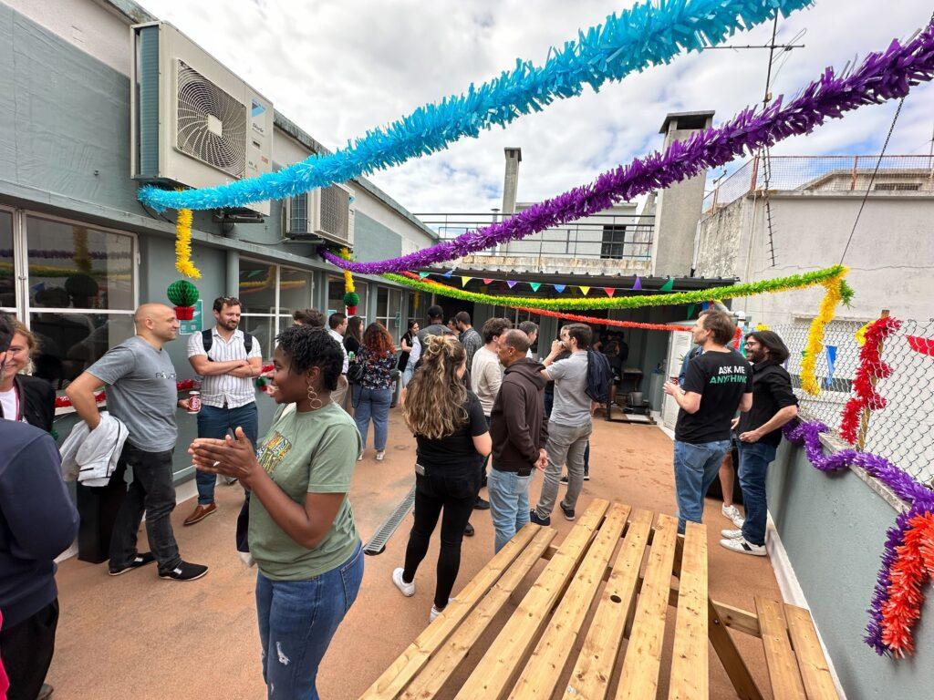 Attendees and Dashlaners mingling on the terrace with colorful, decorative streamers overhead.