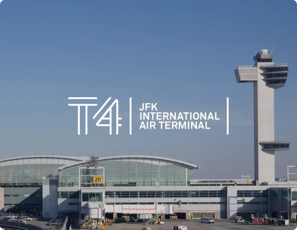 Exterior view of the JFK International Air Terminal building and control tower, featuring the Terminal 4 T4 logo.